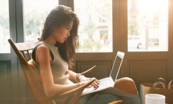 Young Asian woman working on her laptop searching for 1099 jobs